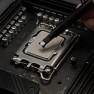 A dab of Kryonaut thermal paste placed on a processor with the spatula attached to the syringe