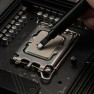 A dab of Kryonaut thermal paste placed on a processor with the spatula attached to the syringe