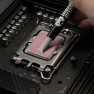 Kryonaut Extreme thermal paste being spread across a processor with the spatula attached to the syringe