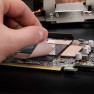 A Minus Pad 8 thermal pad being laid onto a graphics card by hand