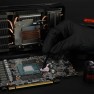 Putty Basic being applied to a graphics card with a spatula, gloves on